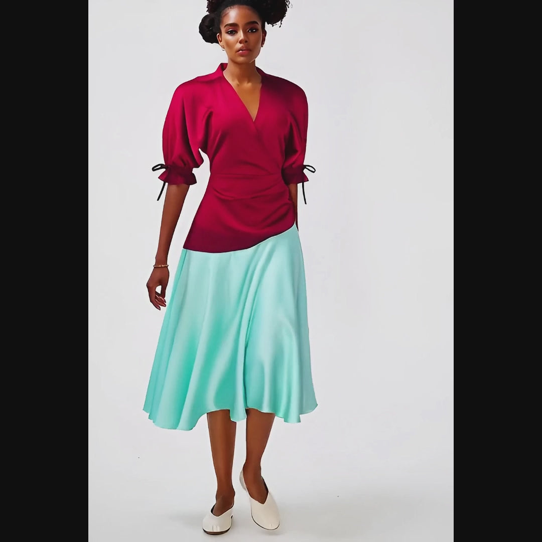Woman wearing a dress with a red top and light blue skirt on a white background