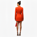 Woman wearing a bright orange dress with a white background