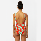 Woman wearing a red and green patterned swimsuit on a white background