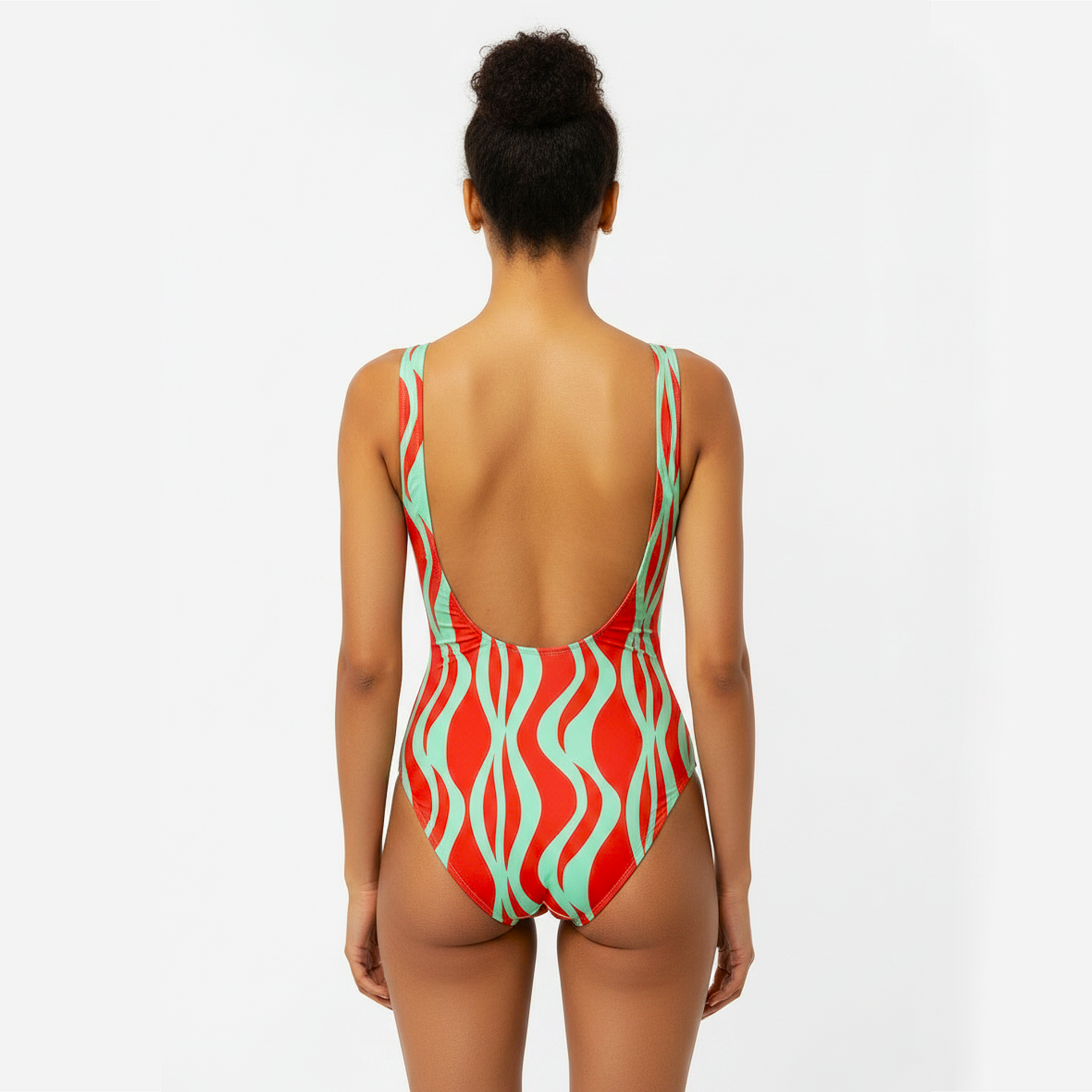 Woman wearing a red and green patterned swimsuit on a white background