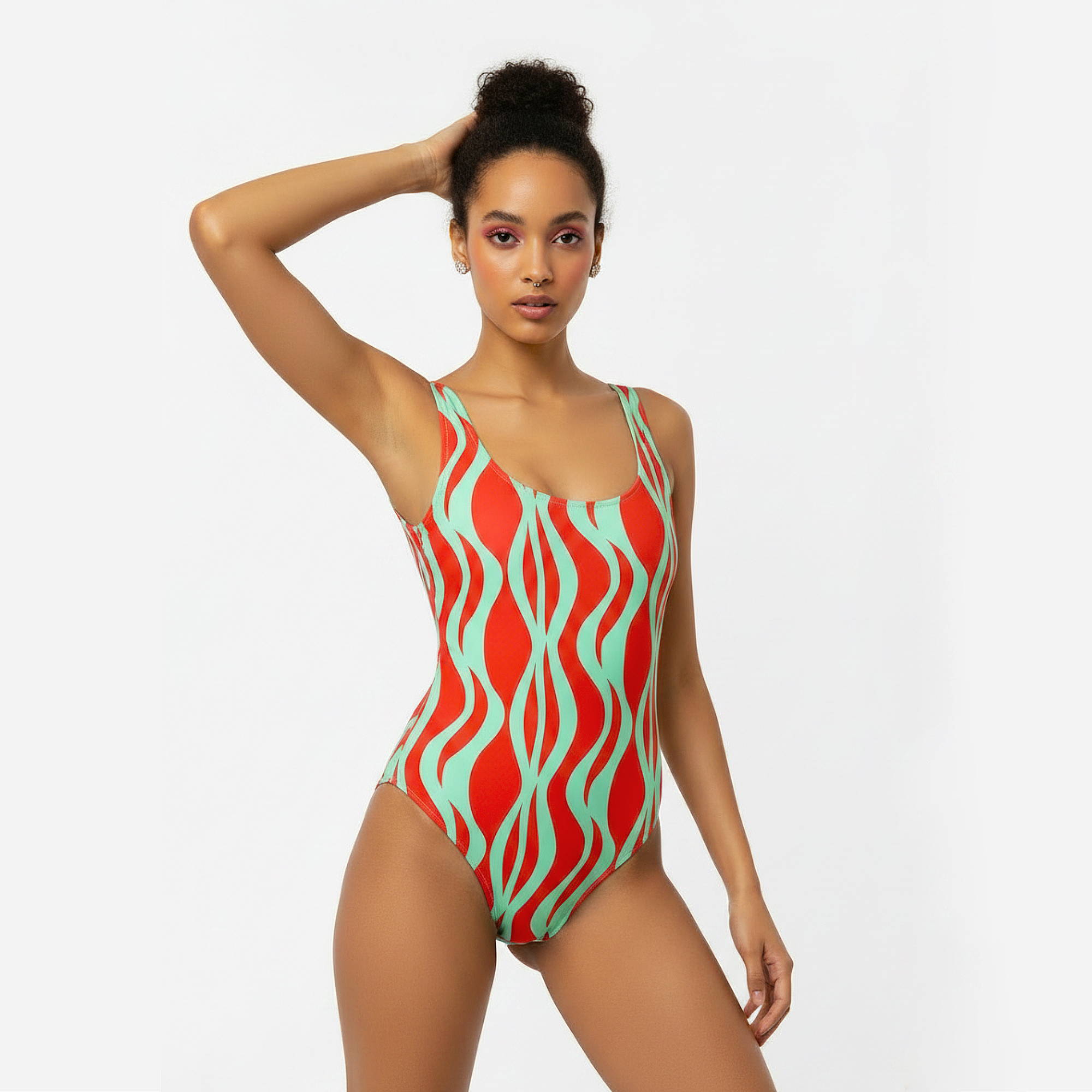 Woman wearing a red and green patterned swimsuit on a white background