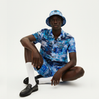 Person wearing a blue patterned outfit with a matching hat on a white background