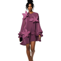Woman wearing a purple dress with floral embellishments on a white background
