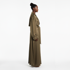 Woman wearing a long beige trench coat on a white background