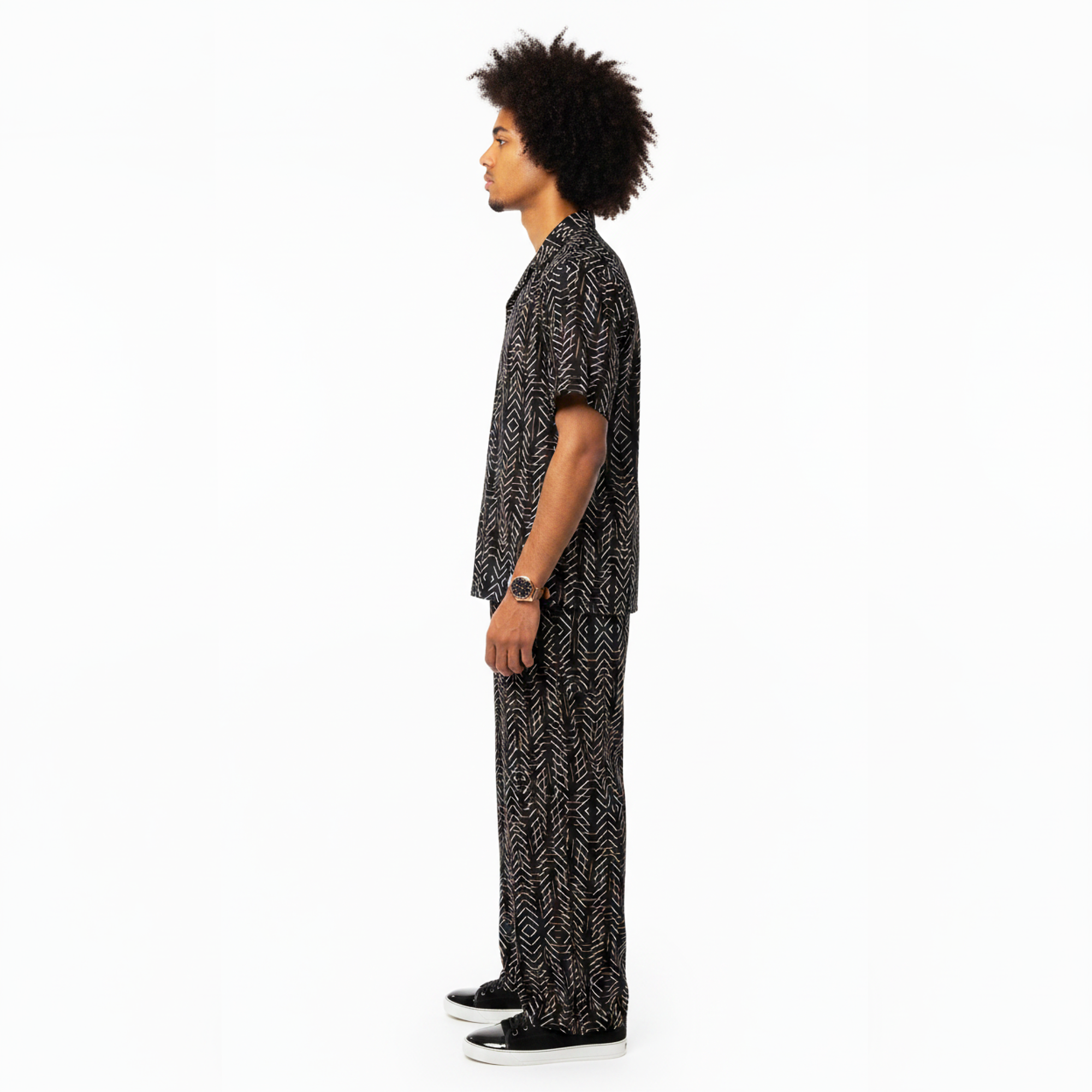 Man wearing a black and white patterned outfit on a white background