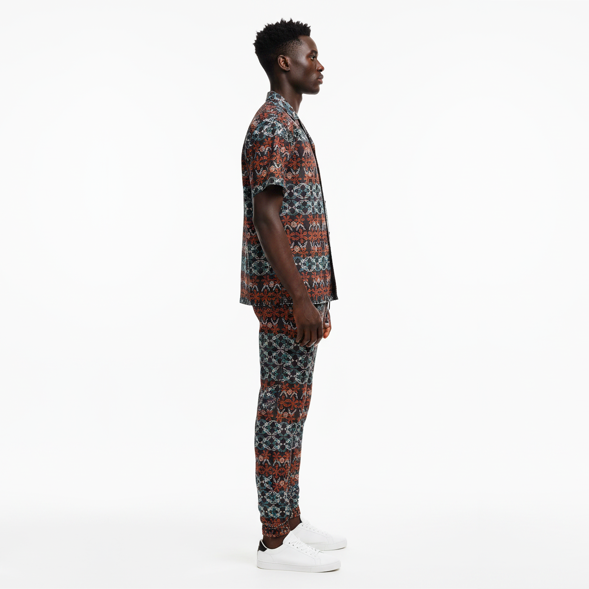 Man wearing a patterned outfit on a white background