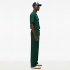Man wearing a green outfit with a cap on a white background