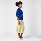 Woman wearing a dress with a  blue top and yellow skirt on a white background