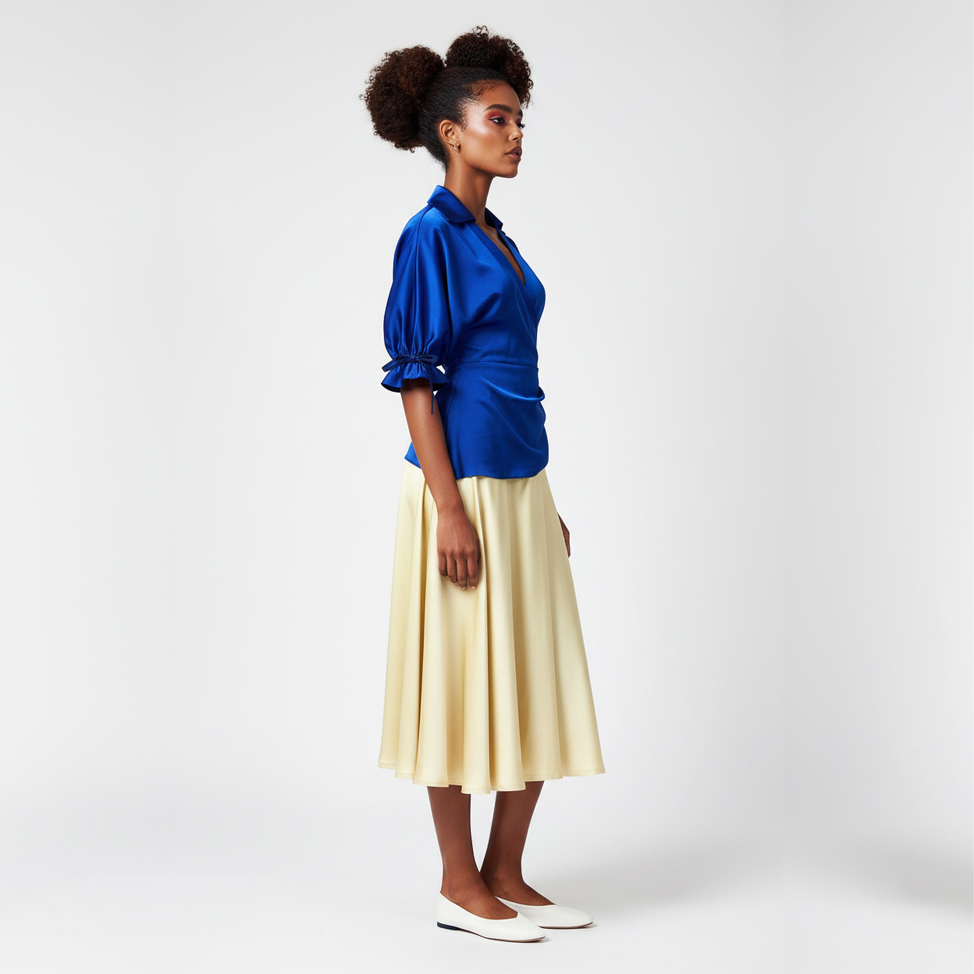 Woman wearing a dress with a  blue top and yellow skirt on a white background