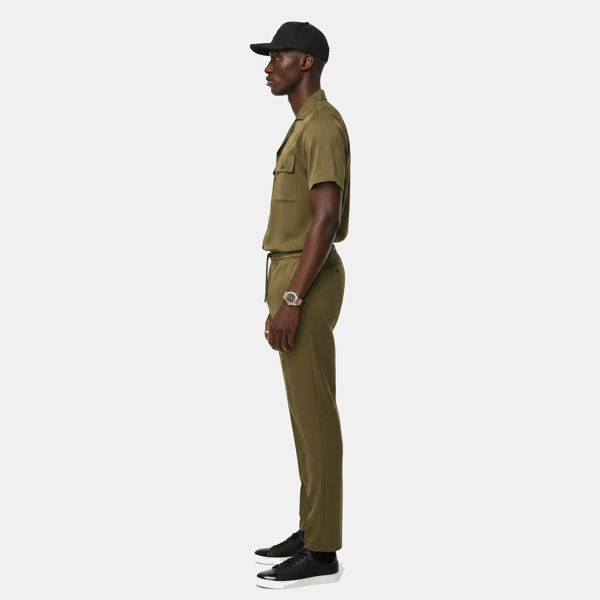 Man wearing a green military-style outfit on a white background