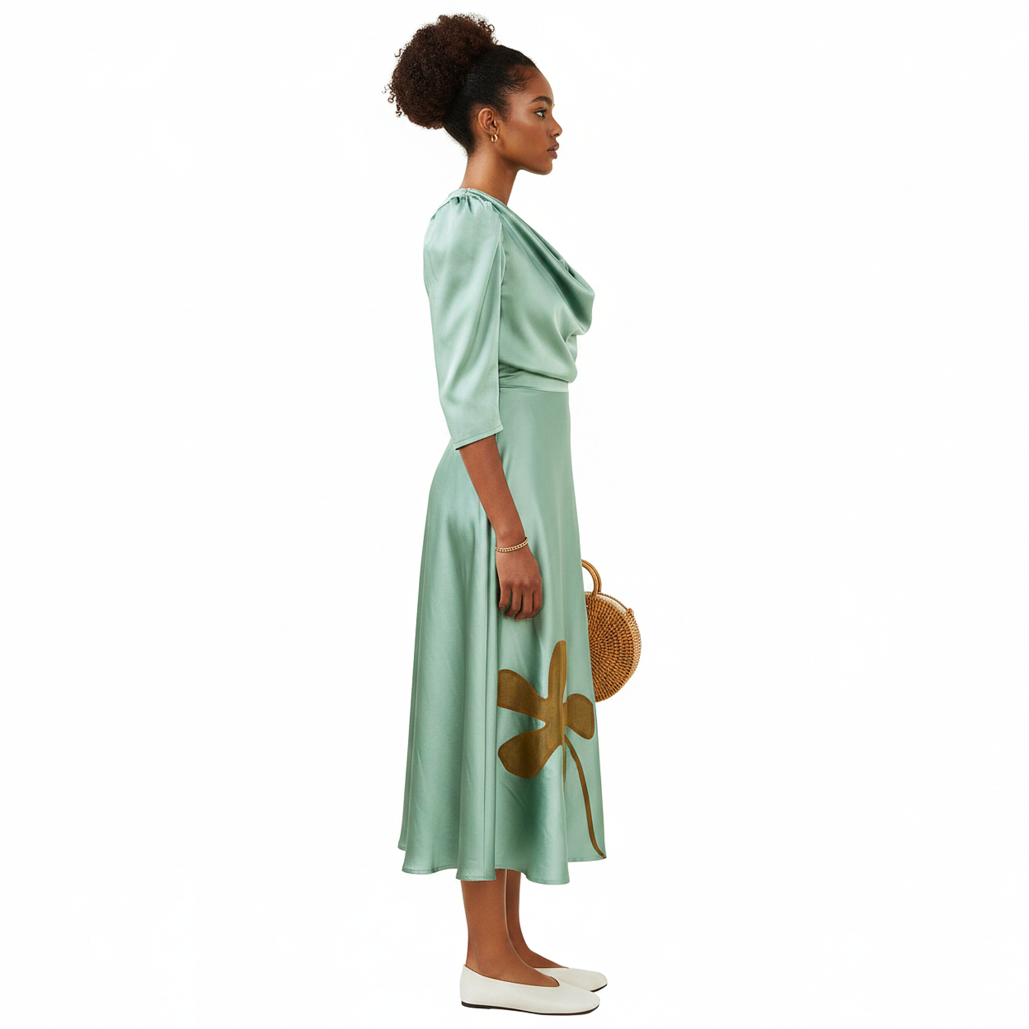 Woman wearing a green dress with floral designs against a white background