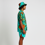 Person wearing a colorful shirt and bucket hat on a plain background