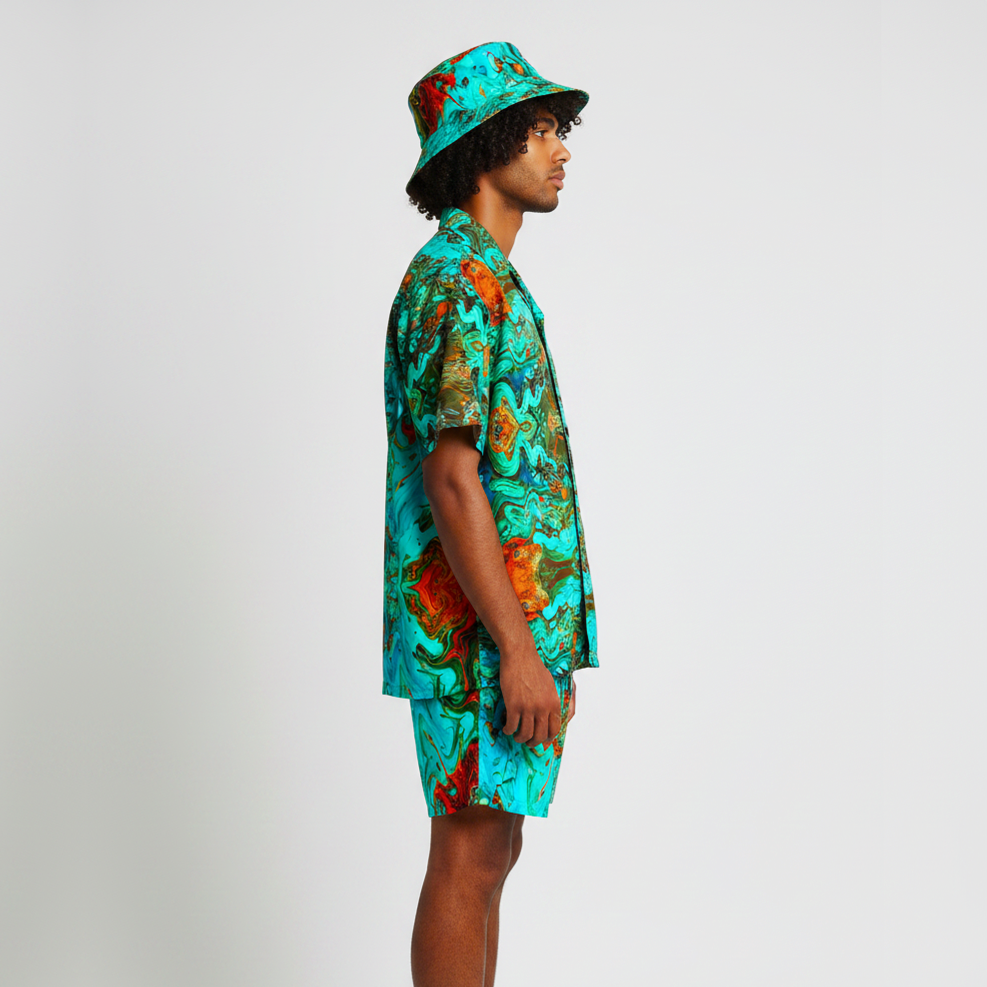 Person wearing a colorful shirt and bucket hat on a plain background