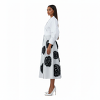 Woman wearing a white coat with black floral patterns on a white background