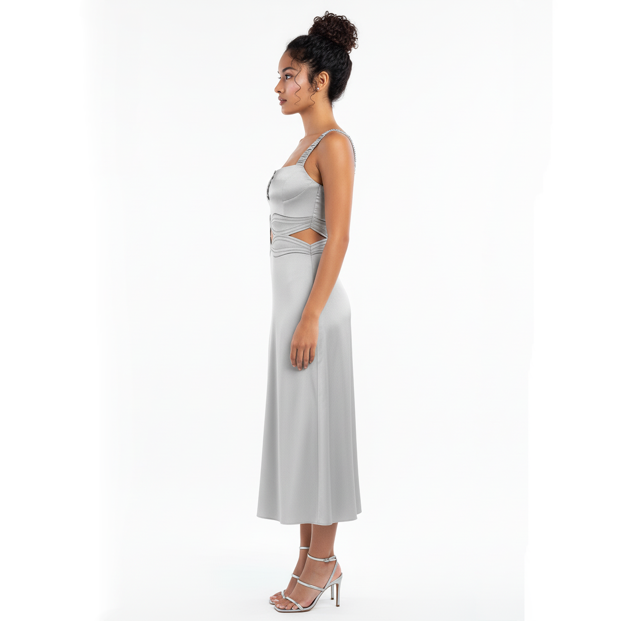 Woman wearing a silver dress with cut-out design on a white background