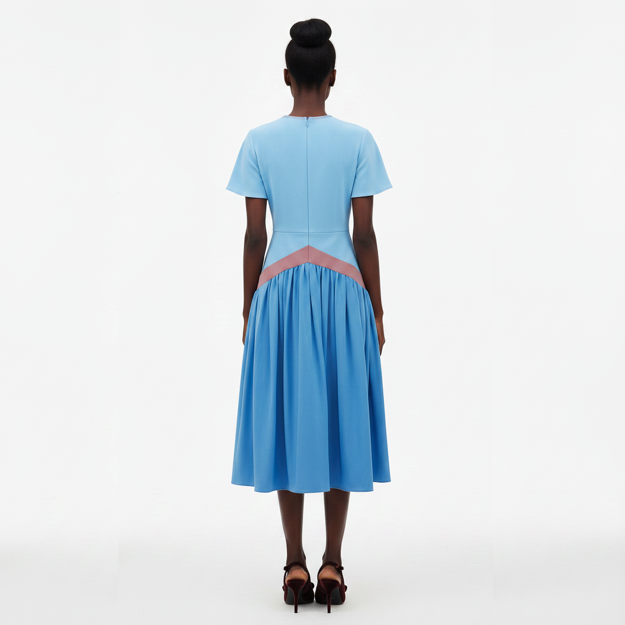 Woman wearing a blue dress with a pink accent on a white background