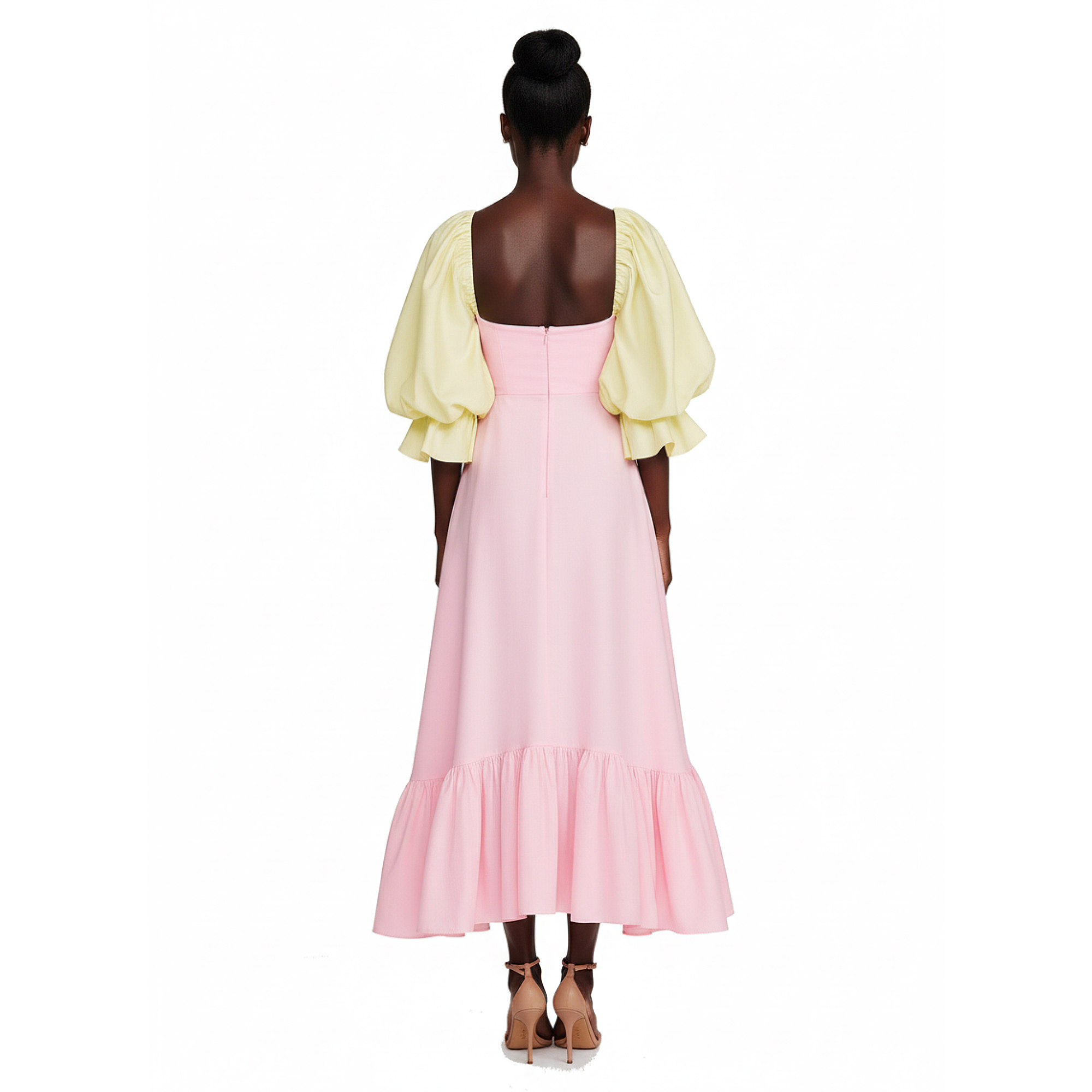 Woman wearing a pink dress with yellow sleeves on a white background