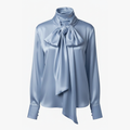 Light blue blouse with a large bow tie on a white background