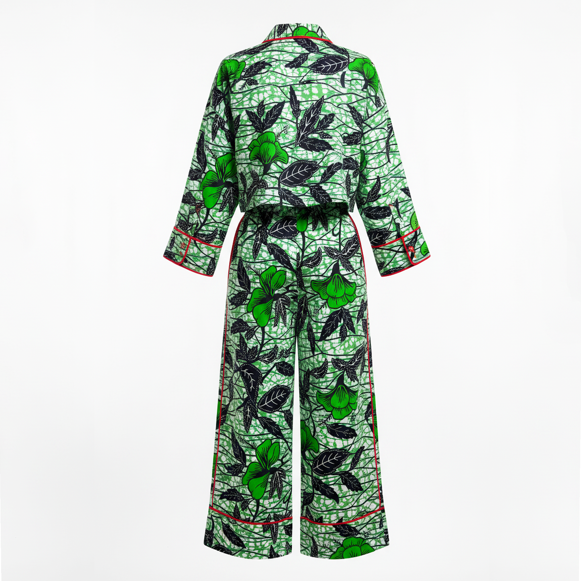 A matching two-piece pajama set with a green and black botanical print of leaves and fruit, featuring red piping accents on the collar, cuffs, and hem, shown against a plain white background.
