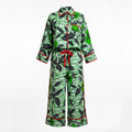 A matching two-piece pajama set featuring a green and black leaf pattern with red piping and a red waist tie, displayed on a white background.