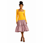 Woman wearing a yellow top and pink skirt on a white background